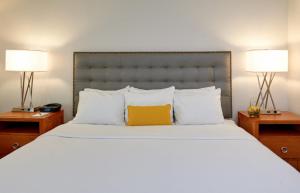 安娜堡肯辛顿酒店的一间卧室配有一张带黄色枕头的大床