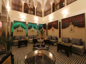 马拉喀什Riad Zaki的大楼内客厅,配有沙发和桌子