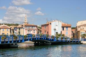 马蒂格Kyriad Direct Martigues的一座城市里一条河上的蓝桥