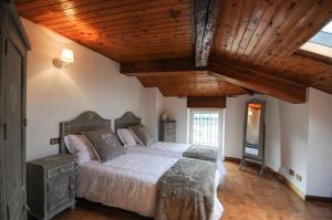 圣费德勒·因特尔维Cà Lisa的一间卧室设有一张大床和木制天花板
