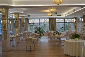 科希策Hotel Slamený dom的用餐室设有桌椅和窗户。