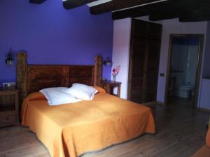普兰莱菲尔塔酒店的一间卧室配有带橙色床单和白色枕头的床。