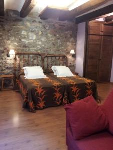 普兰莱菲尔塔酒店的一间卧室设有两张床和石墙