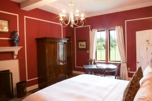 威廉斯堡威德摩尔广场酒店的一间卧室设有红色的墙壁、一张床和一张书桌