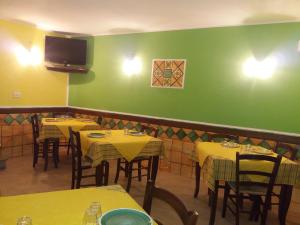 FlorestaHotel Sant'Anna的餐厅设有黄色的桌子和绿色的墙壁