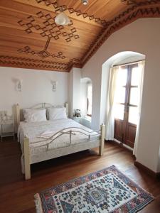 恰纳卡莱艾特朗格特类酒店的一间卧室设有一张床和木制天花板