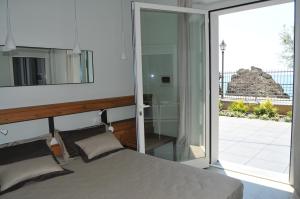 蒙特罗索阿尔马雷Roca Du Ma Pasu的一间卧室设有一张床和一个滑动玻璃门