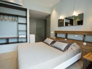 蒙特罗索阿尔马雷Roca Du Ma Pasu的一间卧室配有一张大床和镜子