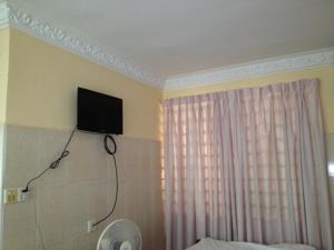 金边139旅馆的卧室墙上的电视机,卧室里配有一张床
