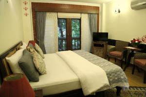 新德里伊思戴特住宿加早餐旅馆的一间卧室设有一张大床和一个窗户。
