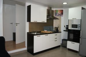 卡斯泰尔诺勒莱卡斯泰尔诺莱别墅一室公寓的厨房配有白色橱柜和黑色台面