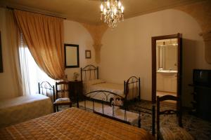 科里利亚诺多特兰托Calì Nitta的一间卧室配有两张床、镜子和吊灯。