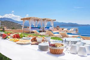 卡斯马尔萨拉酒店的一张白色桌子,上面有食物,在海边