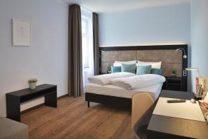科隆UHU Gästehaus Superior的一间卧室配有一张大床和一张桌子