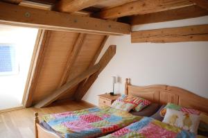 ZweiflingenCarles Scheunenhof的一间带一张床的卧室,位于带木制天花板的房间内
