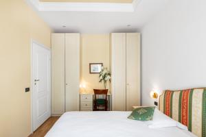 华沙圣安德鲁斯宫公寓的一间小卧室,配有一张床和一把椅子