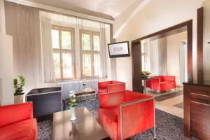 布拉格鲁尼克酒店的客厅配有红色椅子和镜子