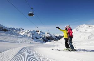 库哈台Sonne & Schnee in Kühtai的两人在滑雪缆车上滑雪