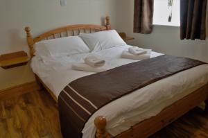 道格拉斯Sea Breeze Guest House的一间卧室配有一张床,上面有两条毛巾