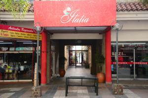 维拉卡洛斯帕兹Hotel Italia的商店前的长凳,有红色标志