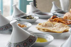 索维拉Riad Kafila的餐桌上放着一碗食物和盘子