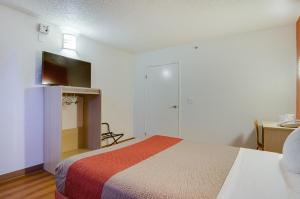 塔科马塔科马南部6号汽车旅馆 的一间卧室配有一张床、一张书桌和一台电视。