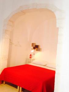 奥斯图尼L'alcova di Garibaldi的一间卧室配有红色的床和红色毯子
