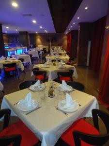 阿尤恩埃米利奥莫雷蒂酒店的用餐室配有白色的桌子和红色的椅子