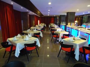 阿尤恩埃米利奥莫雷蒂酒店的餐厅的一排桌子和红色椅子