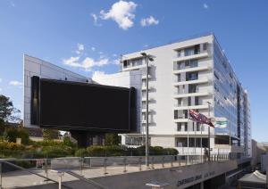 悉尼查茨伍德希尔卡里套房公寓式酒店的大楼前的大广告牌