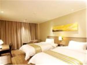 济南如家快捷酒店济南堤口路火车站北广场店的酒店客房配有两张床和一张书桌