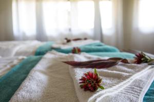 龙杜Gondwana Hakusembe River Lodge的一张带白色毛巾和红色鲜花的床