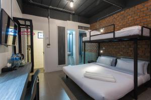甲米镇甲米城市酒店的一间卧室设有双层床和砖墙