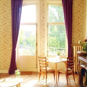 布鲁塞尔布鲁塞尔弗拉耶旅馆的一间带桌椅和窗户的用餐室