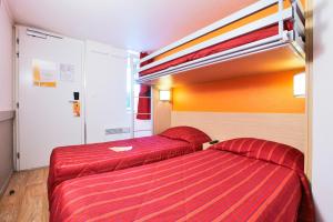 皮勒博罗北拉罗谢尔 - 珀博瑞普瑞米尔经典酒店的两张位于酒店客房的床铺,配有红色床单