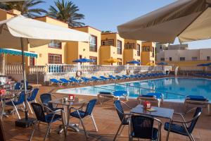 科拉雷侯马克索拉塔海滩公寓酒店的酒店庭院设有桌椅和游泳池。