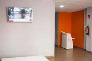 阿尔苏阿De Camino的墙上有电视,墙上有橙色的墙壁
