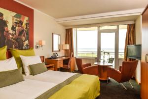滨海卡特韦克北海酒店的酒店客房设有一张床和一个大窗户