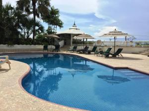 阿卡普尔科Villa Guitarron gran terraza vista espectacular 6 huespedes piscina gigante的一个带椅子和遮阳伞的大型游泳池