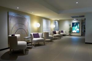 霍索恩区Corporate Living Accommodation Hawthorn的一间设有白色椅子和电视的等候室