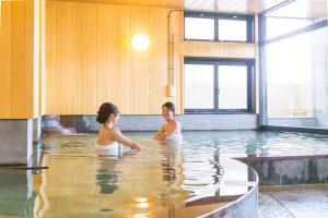 嬉野市嬉野元汤日式旅馆的两名妇女在游泳池游泳