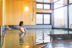 嬉野市嬉野元汤日式旅馆的坐在游泳池的水中的女人