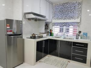 龙运乌米宾馆的白色的厨房配有水槽和冰箱