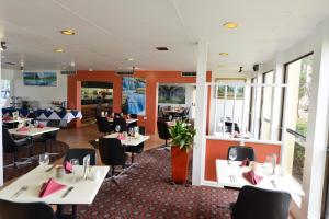 班达伯格Bundaberg International Motor Inn的一间设有白色桌子和黑色椅子的餐厅