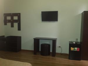 加格拉Inn Rif的一间设有桌子的房间和墙上的电视