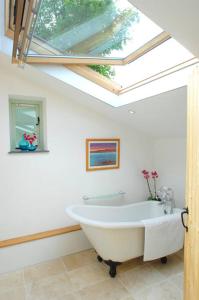 特鲁罗舒适度假屋的带浴缸的浴室和天窗