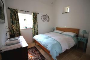 特鲁罗舒适度假屋的一间卧室设有一张床和一个窗口