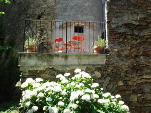 MagnanoAppartamenti a Magnano的两把红色椅子坐在带鲜花的阳台