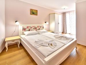 奥布佐尔Sirena Palace Family Hotel的卧室配有带毛巾的大型白色床
