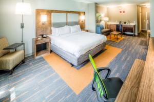 韦斯特莱克Holiday Inn Express & Suites Cleveland/Westlake, an IHG Hotel的配有一张床和一把椅子的酒店客房